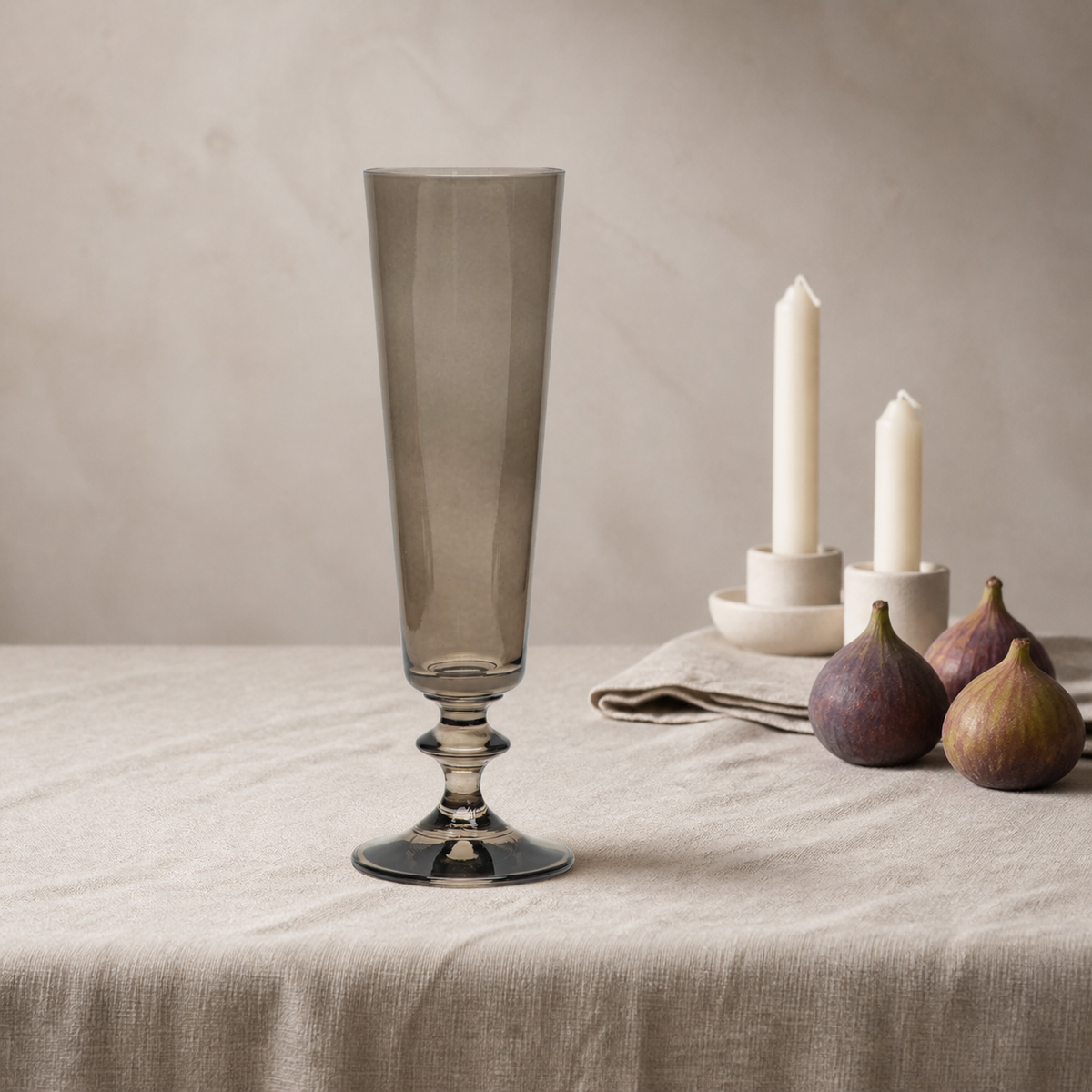 Pontil champagne flute in Umber, a warm smoke-brown crystal flute, on a linen tablecloth