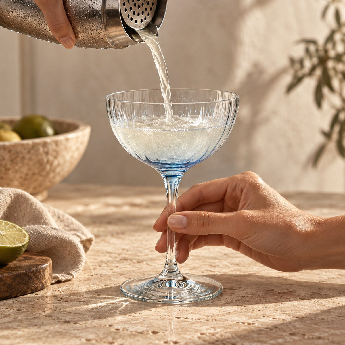 Lume Delft reeded coupes with a cocktail being strained into a coupe