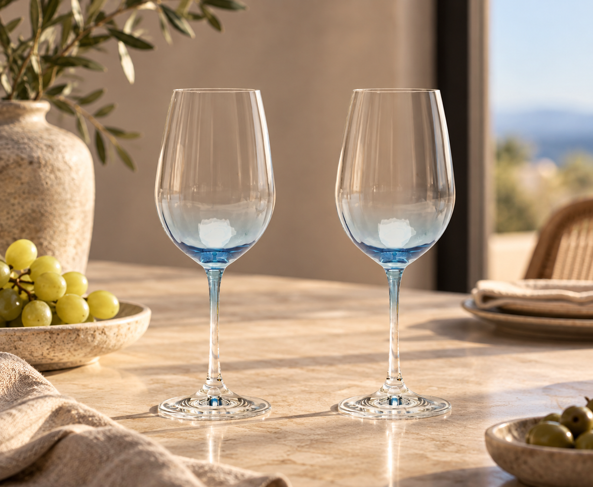 Two Lume reeded crystal wine glasses in Delft blue on a sunlit stone table