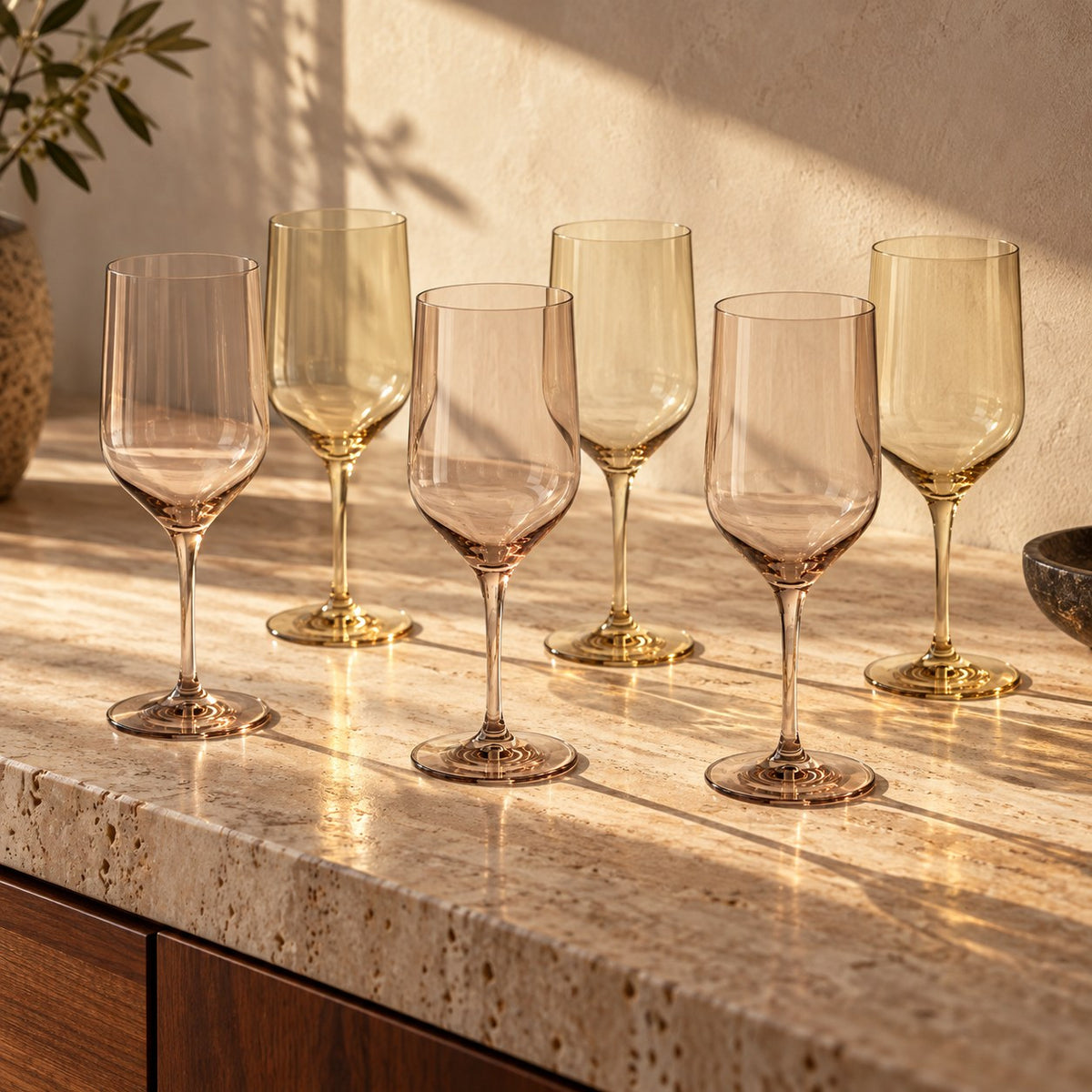 Marver Alabaster and Ochre wine glasses set on a travertine sideboard
