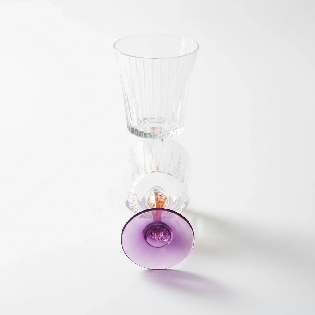Tint & Form Vesper crystal wine glass with a clear vertical-cut bowl and a gradient purple and gold stem.
