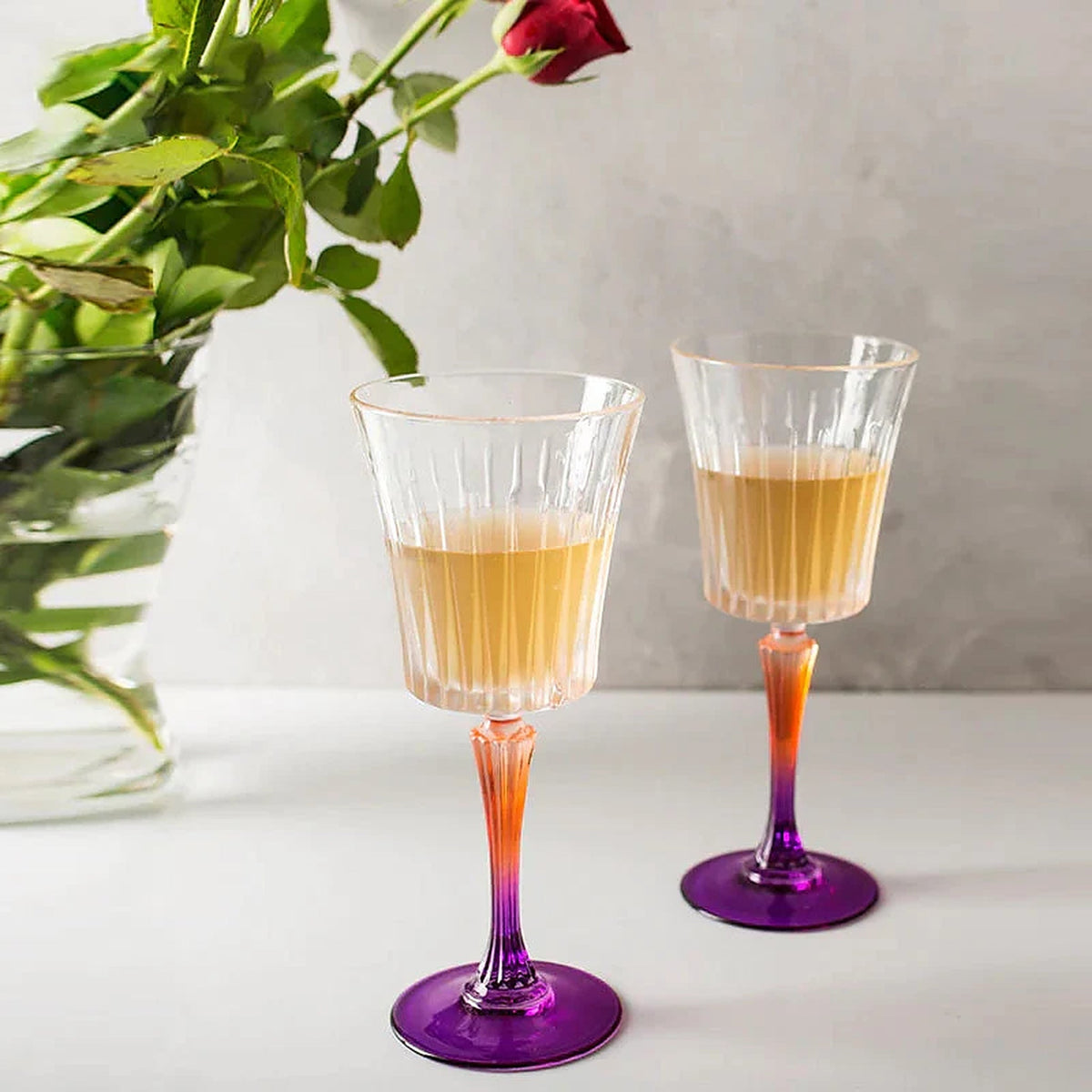 Tint & Form Vesper handblown crystal wine glasses with clear vertical-cut bowls and gradient gold-to-cobalt stems.